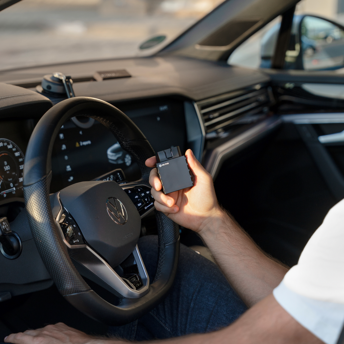 localizzatore gps OBD in mano ad una persona in macchina